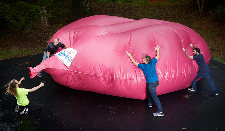 largest whoopie cushion pushed down by three men