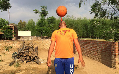 man spinning basketball on toothbrush