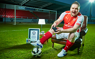 christopher on football pitch with a football and his gwr certificate