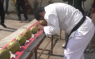 man breaking coconuts with head