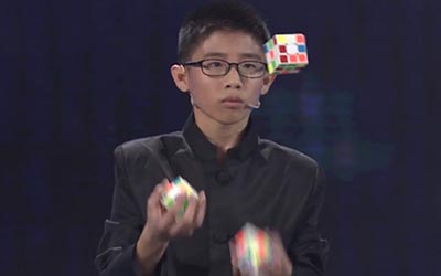 man juggling while solving rubiks cube